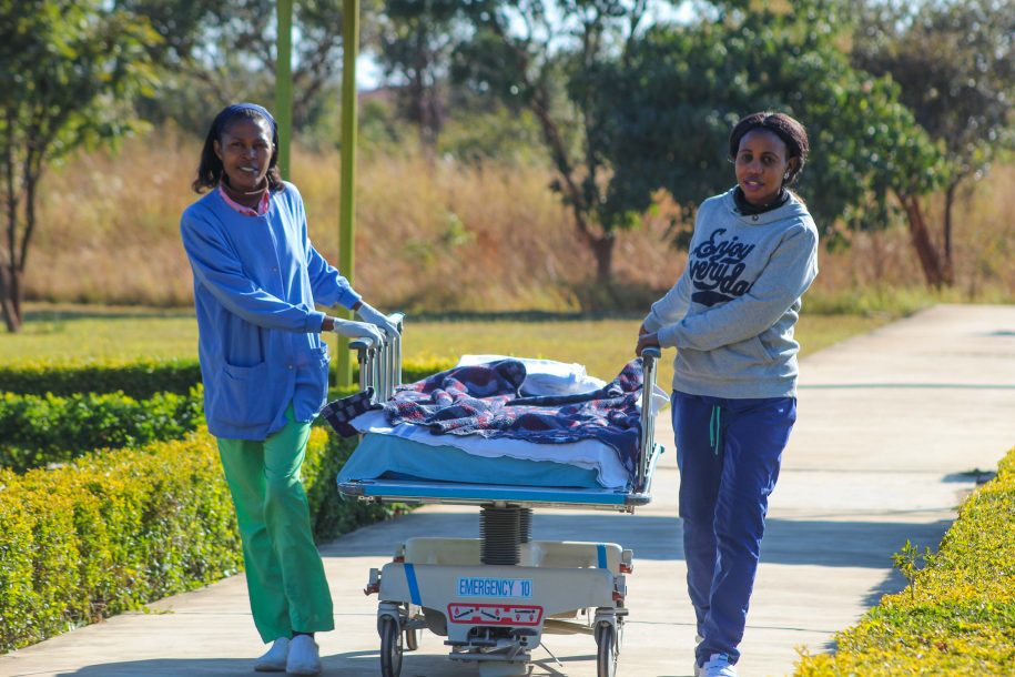 Nurses joyfully wheel a kid from surgery.